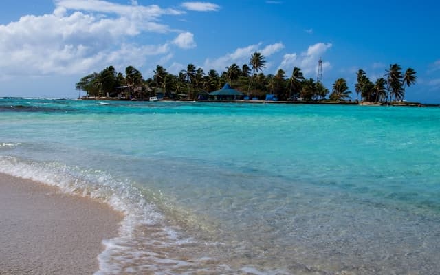 Rajska plaża z turkusową wodą i palmami na tropikalnej wyspie.