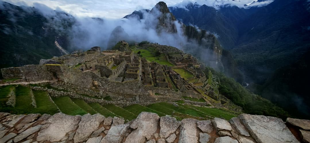 Starożytne ruiny Machu Picchu w Peru otoczone mgłą i górami.