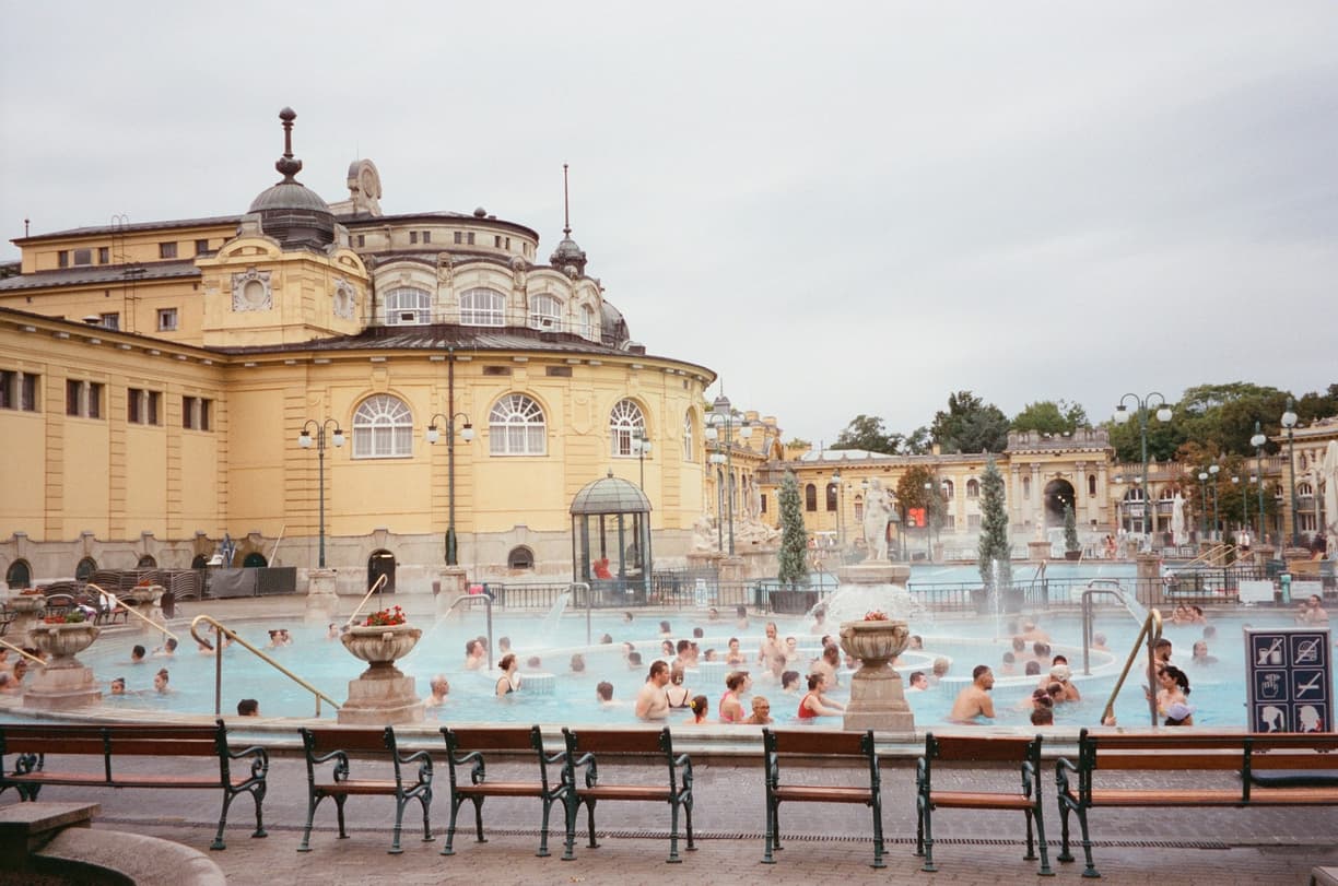 Zabytkowe Termy Szechenyi w Budapeszcie, ludzie kąpiący się w parujących basenach.