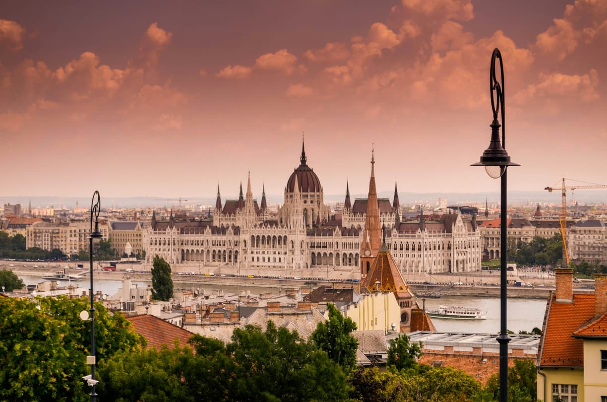 Budapeszt: majestatyczny Parlament nad Dunajem, pomarańczowy zachód słońca.