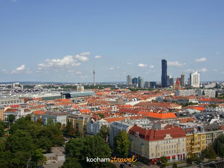 Słoneczna panorama Wiednia z tradycyjnymi budynkami i nowoczesnymi wieżowcami.