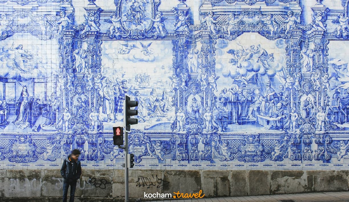 Niebiesko-białe azulejos na ścianie przedstawiające sceny historyczne w Porto.