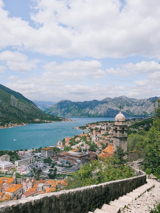 Kotor, Czarnogóra: zabytkowe miasto, zatoka i góry z wieżą kościelną.