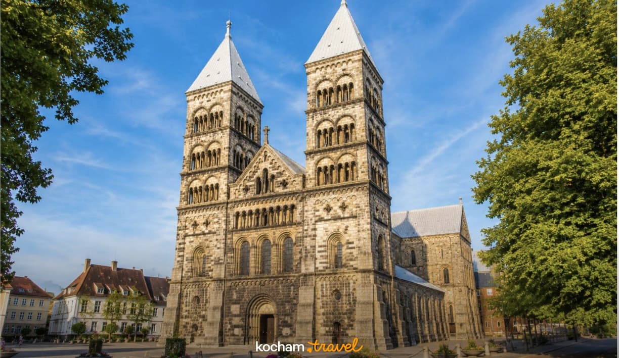 Romańska Katedra w Lund z imponującymi wieżami na tle błękitnego nieba.
