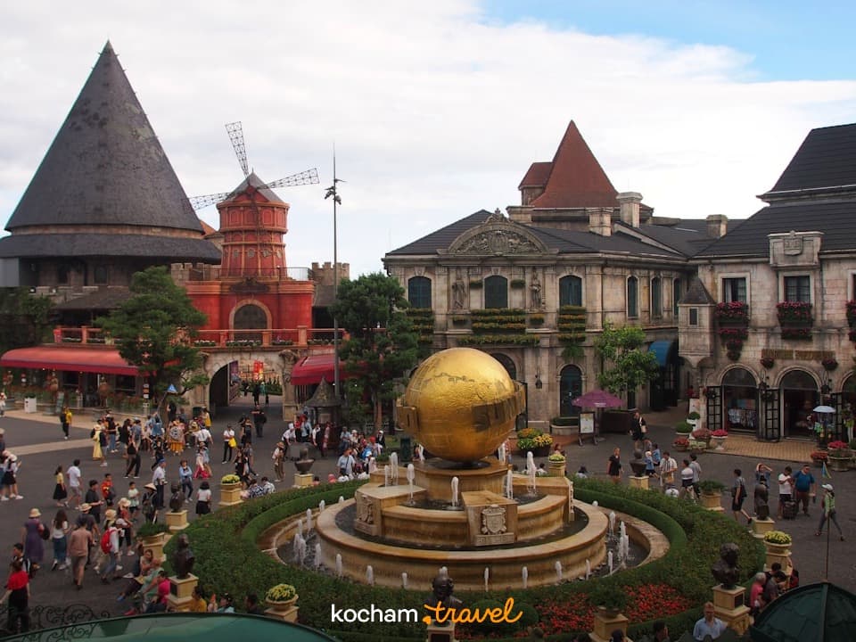 Europejski rynek, złota fontanna globus, unikalna architektura, wielu turystów.