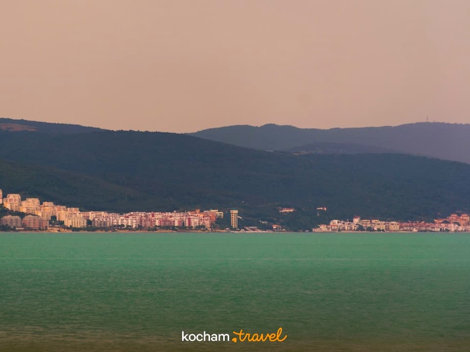 Panorama nadmorskiego miasta, turkusowa woda, zielone góry