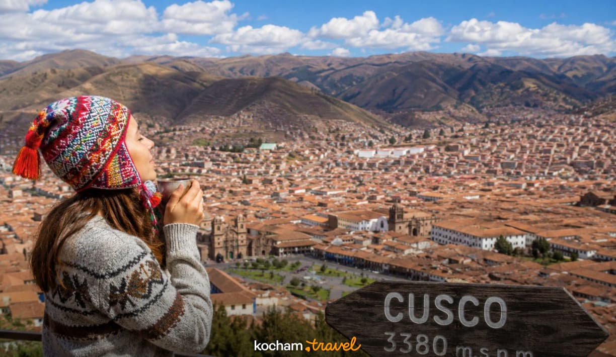Podróżniczka w czapce chullo podziwia panoramę peruwiańskiego Cusco.
