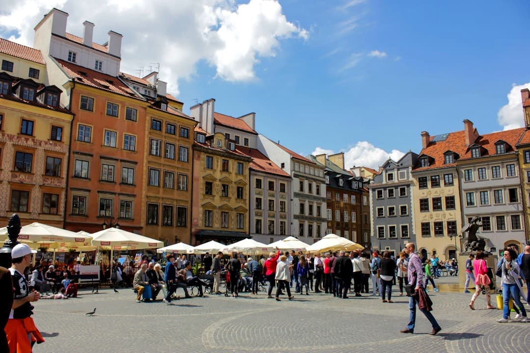 Kolorowe kamienice i turyści na Rynku Starego Miasta w Warszawie.