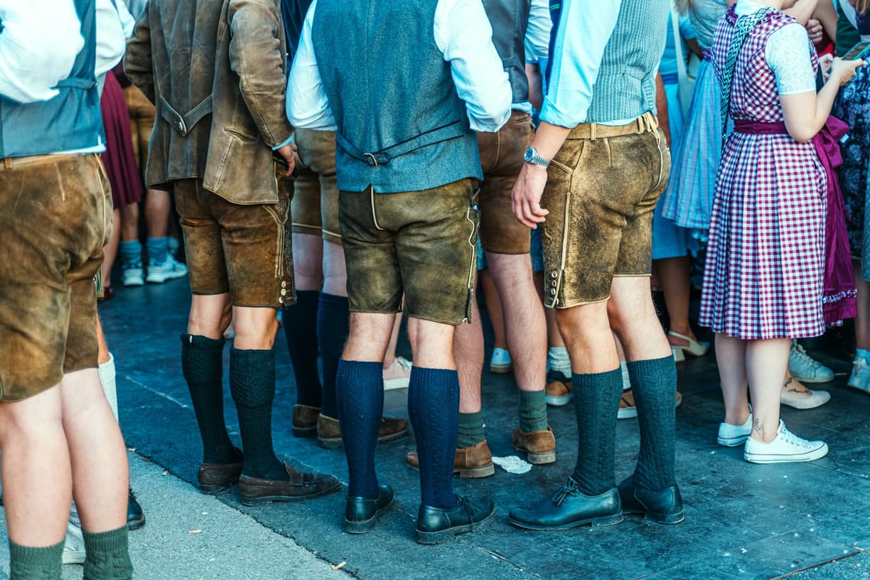 Uczestnicy Oktoberfest w skórzanych spodenkach i tradycyjnych strojach.