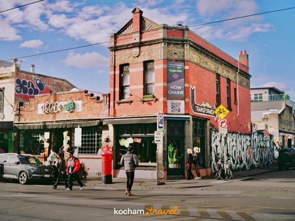 Czerwony ceglany budynek, bar, graffiti, ruchliwa ulica miejska.