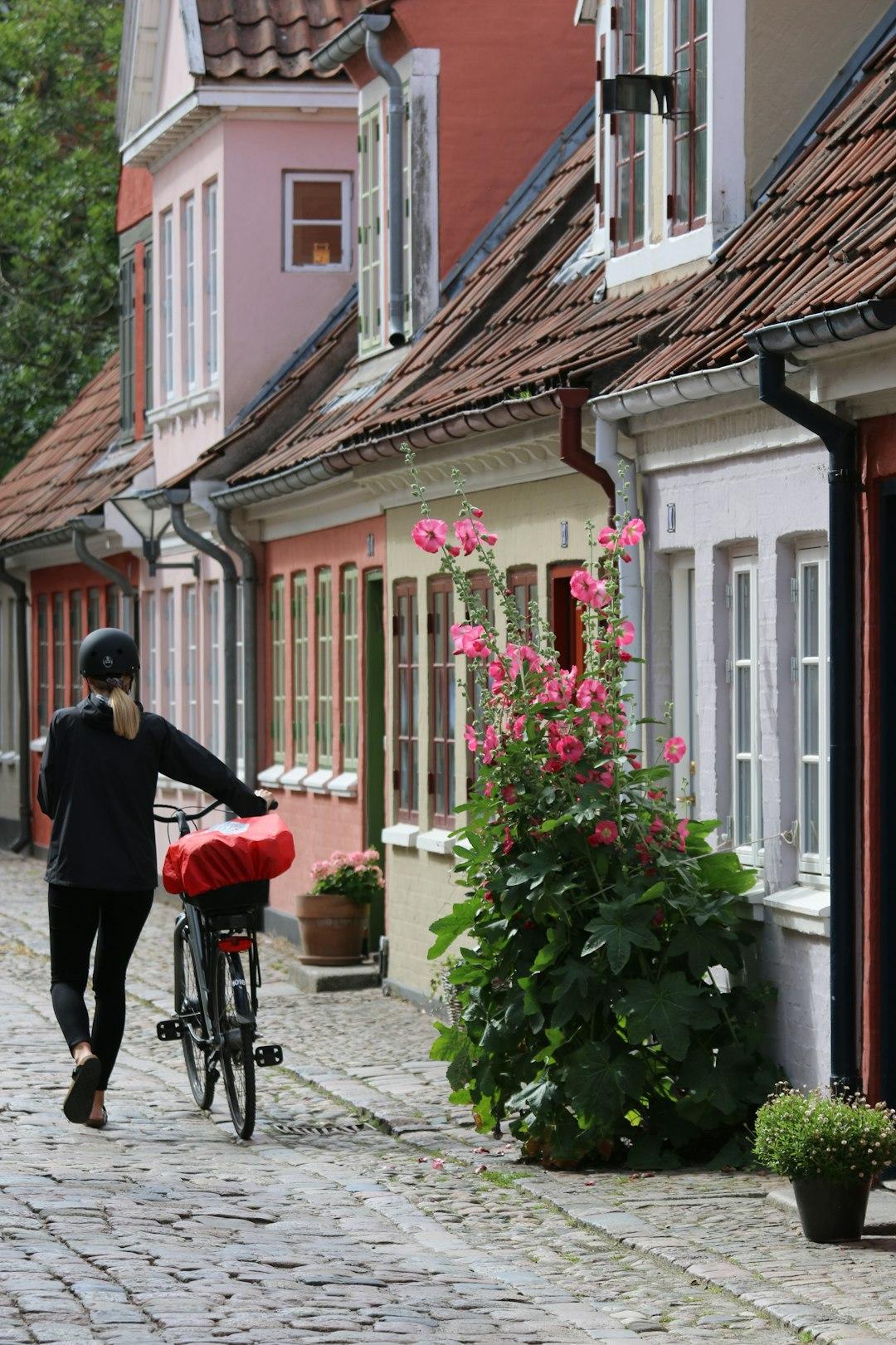 Ulica z kolorowymi domami i rowerzystą w kasku