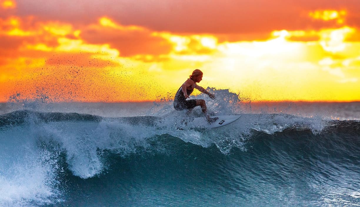 Surferzy na plaży Seminyak podczas zachodu słońca