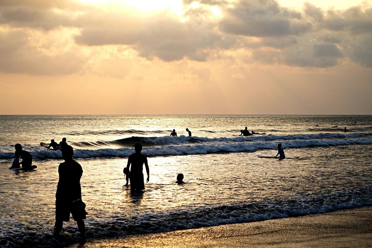Zachód słońca na Kuta Beach z surferami